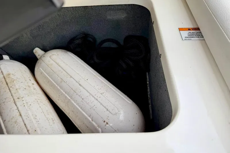 Slide: The Image of Storage compartment with boat fenders and rope on a 2020 Sea Ray SPX 210 Outboard. - 22