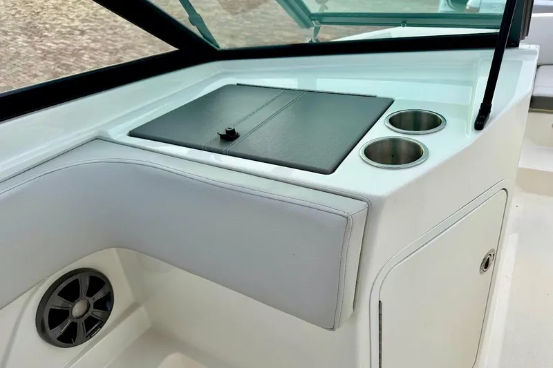 Slide: The Image of 2020 Sea Ray SPX 210 Outboard interior with cup holders and storage compartment. - 28