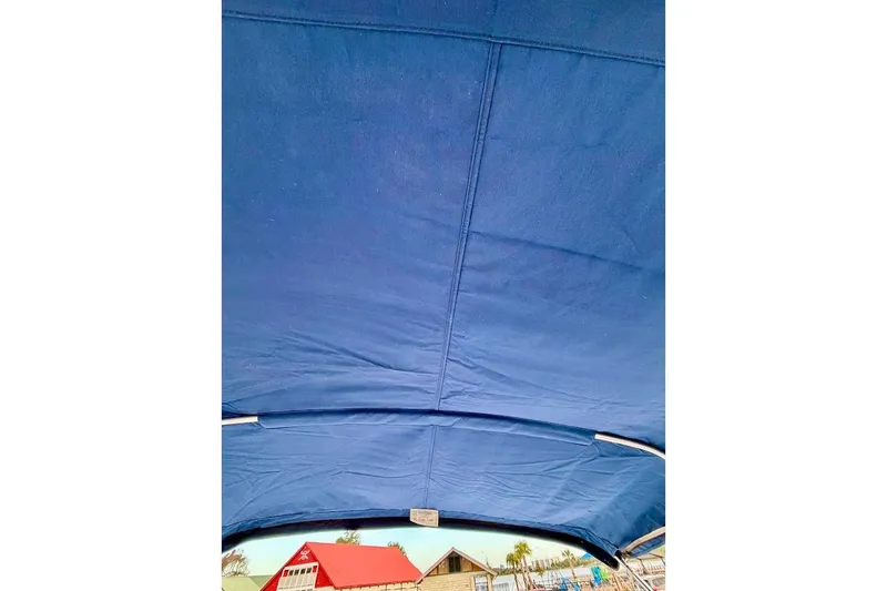 Slide: The Image of Blue canopy of a 2020 Sea Ray SPX 210 Outboard boat with a scenic background. - 30