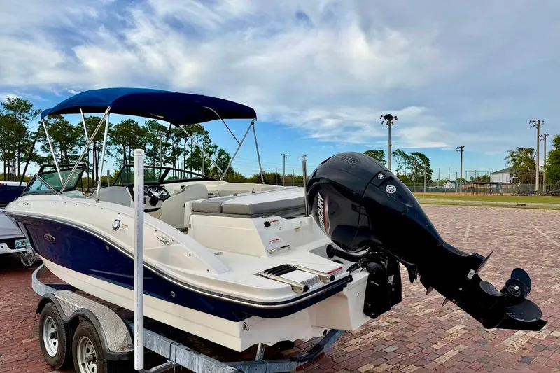Slide: The Image of 2020 Sea Ray SPX 210 Outboard boat on trailer, blue and white design, outdoor setting. - 4