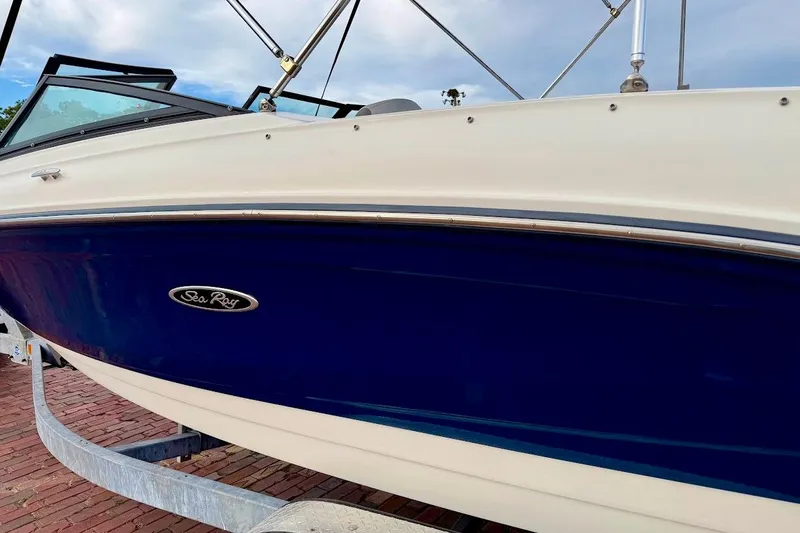 Slide: The Image of 2020 Sea Ray SPX 210 Outboard boat with blue and white hull on trailer. - 5