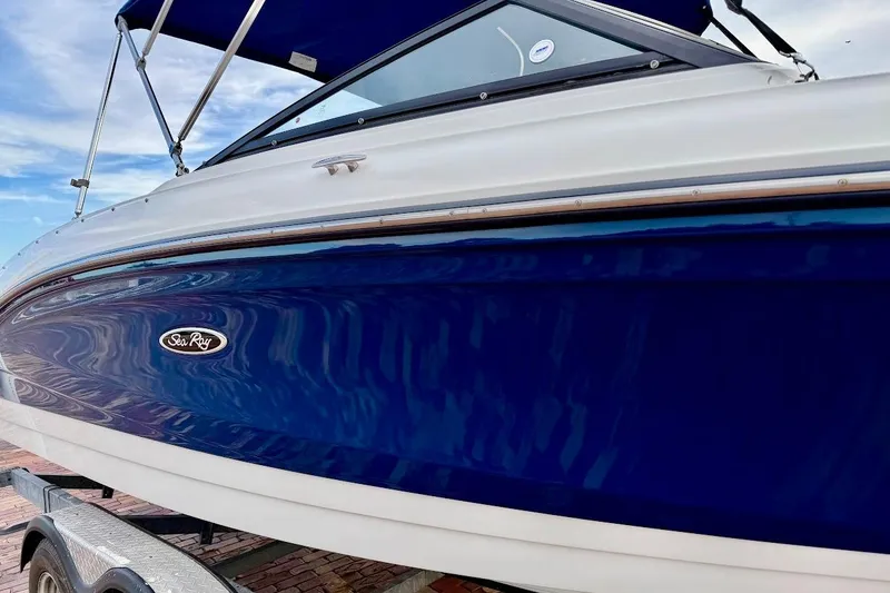 Slide: The Image of 2020 Sea Ray SPX 210 Outboard boat with blue hull and canopy. - 9
