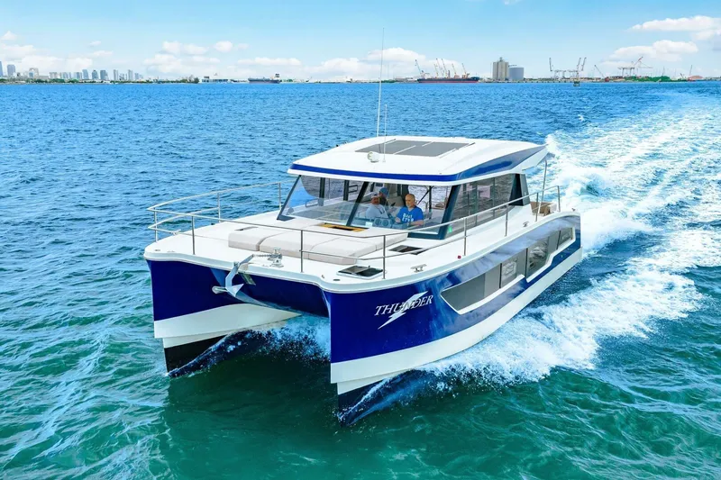 Slide: The Image of 2021 Fountaine Pajot MY4.S catamaran cruising on open water, city skyline in background. - 100