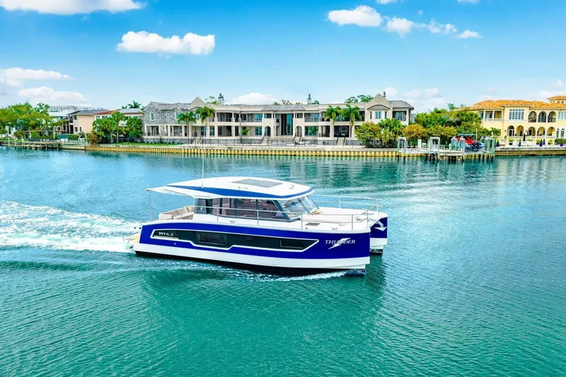 Slide: The Image of 2021 Fountaine Pajot MY4.S yacht cruising on a scenic waterfront with luxury homes. - 79