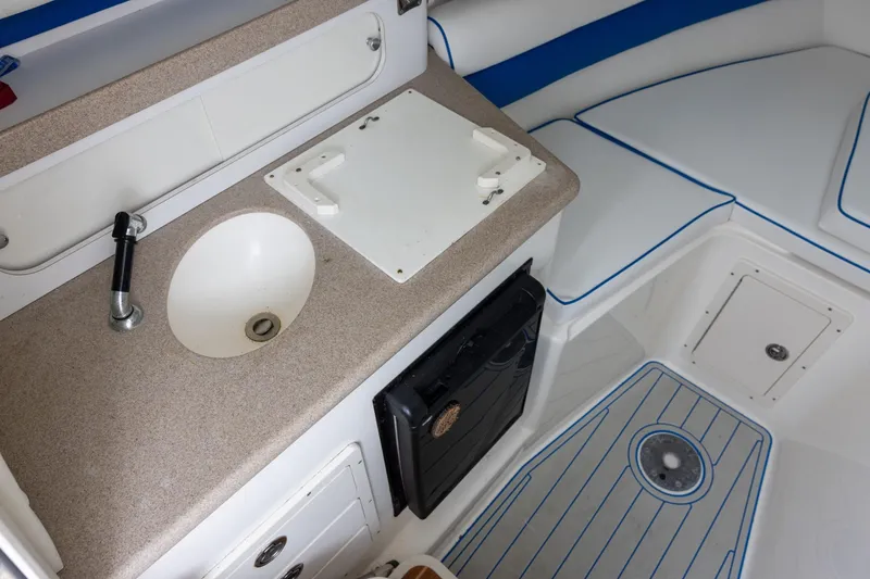 Slide: The Image of 2008 Century 2400 Walk-Around boat interior with sink, countertop, and seating area. - 10