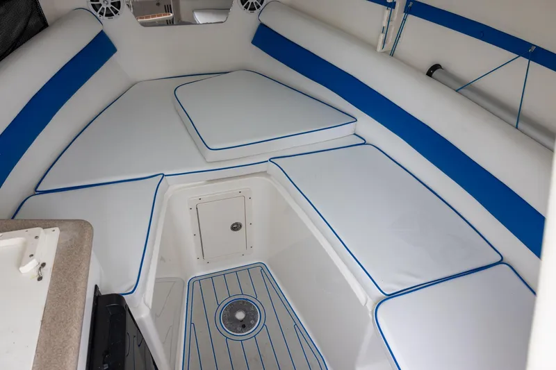 Slide: The Image of Interior of a 2008 Century 2400 Walk-Around boat with cushioned seating and storage. - 11