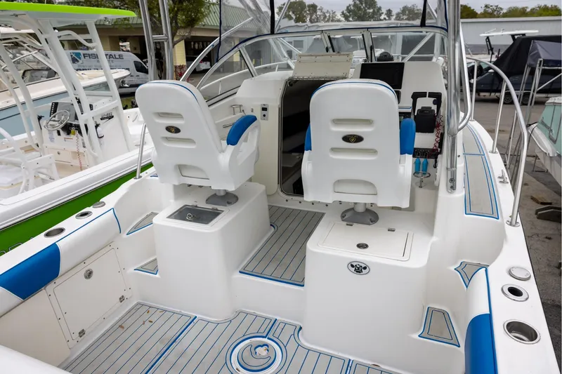 Slide: The Image of 2008 Century 2400 Walk-Around boat interior with dual white captain chairs and blue accents. - 5