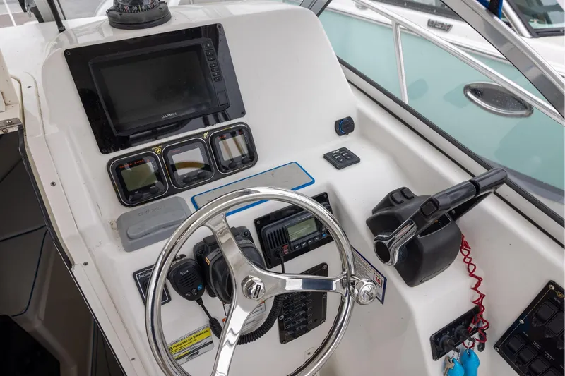 Slide: The Image of Helm of 2008 Century 2400 Walk-Around boat with steering wheel and navigation instruments. - 7