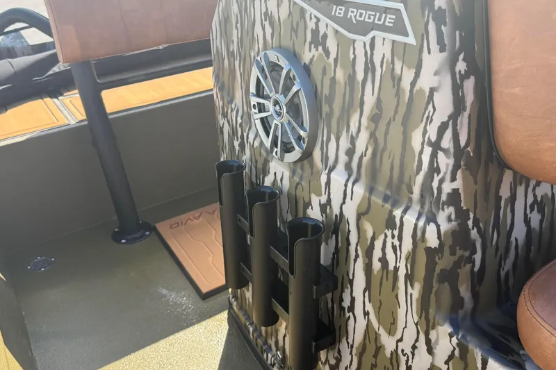 Slide: The Image of 2026 Avid 18 Rogue CC boat interior with camo design and rod holders. - 17