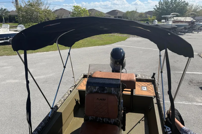 Slide: The Image of 2026 Avid 18 Rogue CC boat with canopy in a parking area. - 18