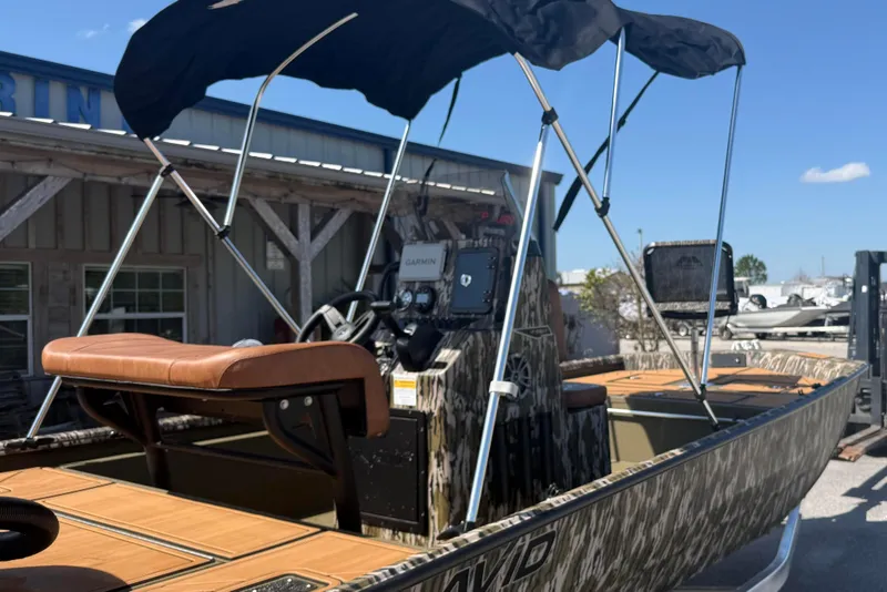 Slide: The Image of 2026 Avid 18 Rogue CC boat with canopy and Garmin equipment, docked outdoors. - 19