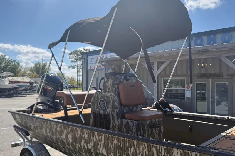 Slide: The Image of 2026 Avid 18 Rogue CC boat with camouflage design and canopy in dealership lot. - 20