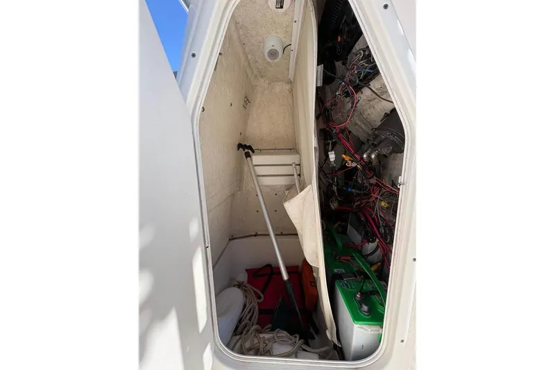 Slide: The Image of Interior view of a 2016 KEYWEST 210 BR boat storage compartment with wiring and equipment. - 16