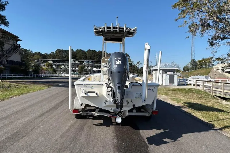 Slide: The Image of 2016 KEYWEST 210 BR boat with outboard motor on a trailer, parked outdoors. - 3