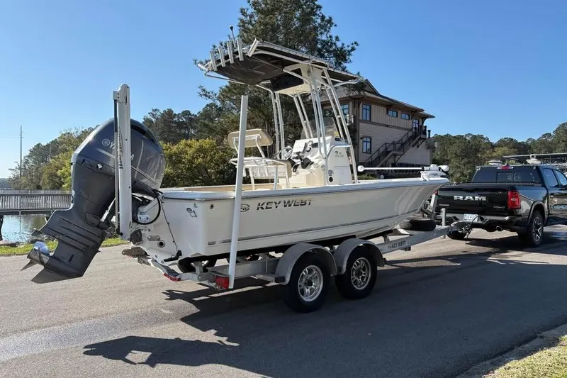 Slide: The Image of 2016 KEYWEST 210 BR boat on trailer, hitched to a RAM truck, near a waterfront. - 4