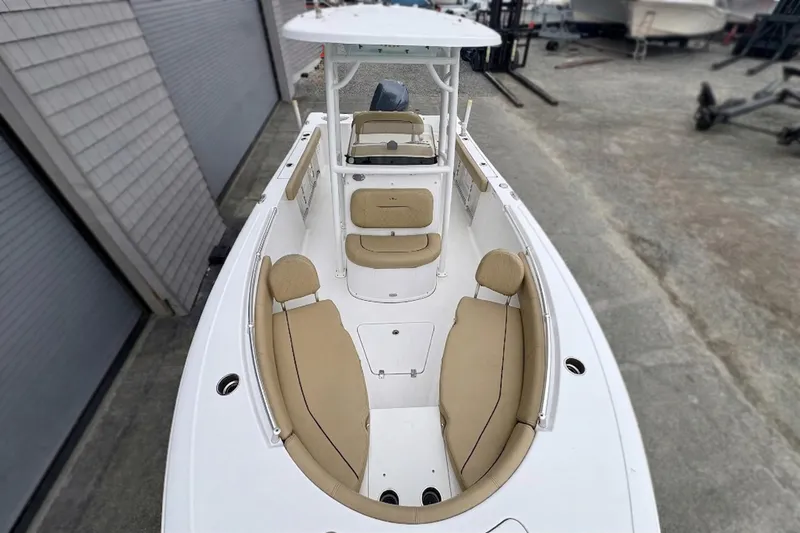 Slide: The Image of 2019 Sportsman Open 232 Center Console boat with beige seating, docked outdoors. - 4