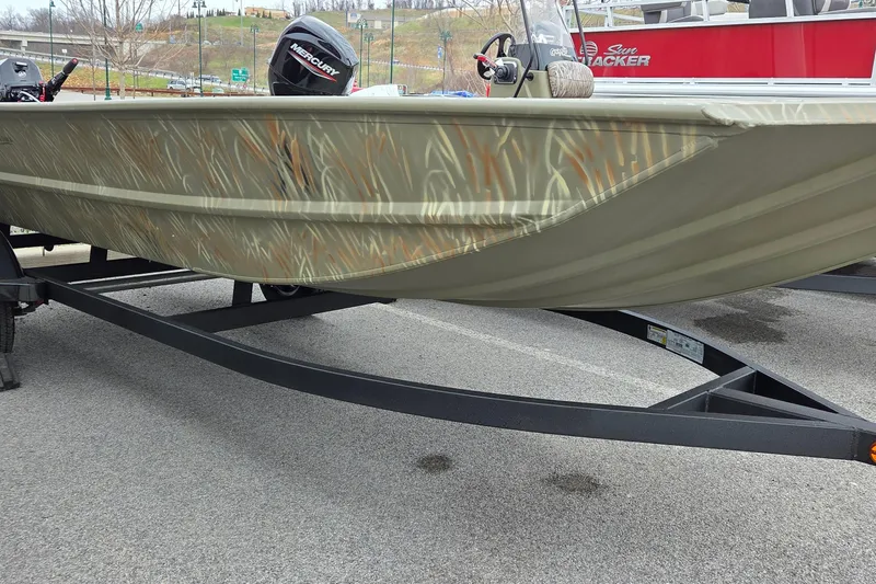 The Image of 2025 Tracker Grizzly 1754 AWL boat with camouflage design on a trailer. - 1