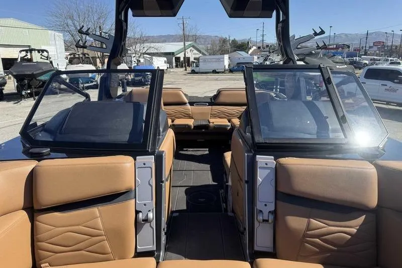 Slide: The Image of 2025 Supra SA boat interior with tan leather seats and open windshield design. - 14