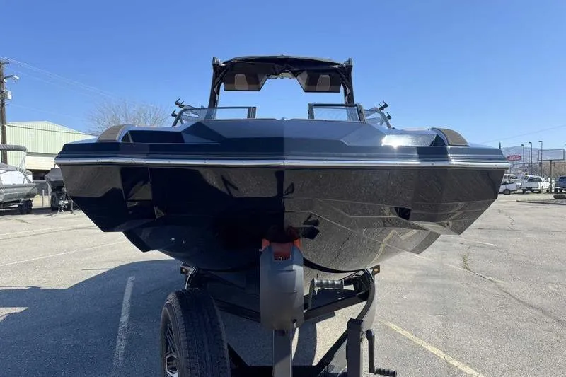 Slide: The Image of 2025 Supra SA boat on trailer, front view under clear blue sky. - 2