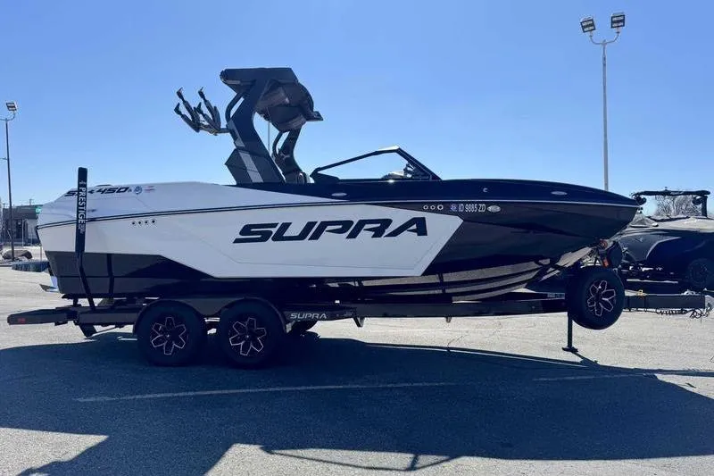 Slide: The Image of 2025 Supra SA boat on trailer in parking lot, side view. - 5