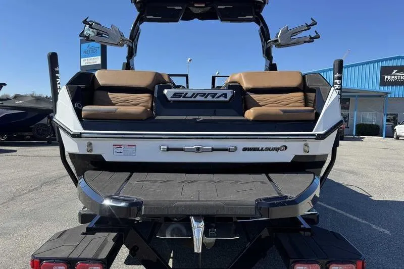 Slide: The Image of 2025 Supra SA boat rear view with brown seating and SwellSurf technology. - 6