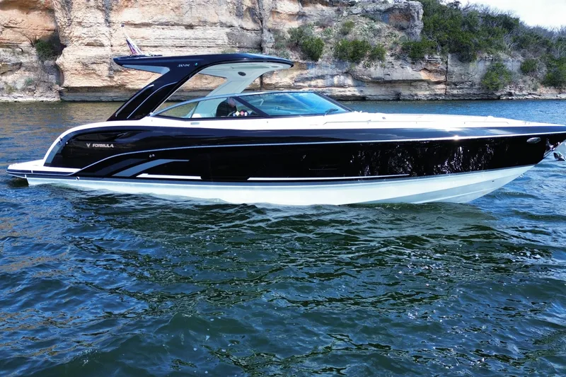 The Image of 2026 Formula 360 Crossover Bowrider I/O on scenic water with rocky cliffs. - 1
