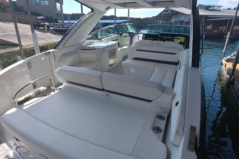 Slide: The Image of 2026 Formula 360 Crossover Bowrider I/O with luxurious seating and modern design at a marina. - 11