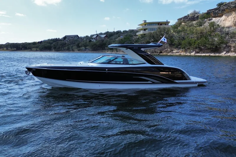 Slide: The Image of 2026 Formula 360 Crossover Bowrider I/O on scenic lake with modern architecture backdrop. - 3