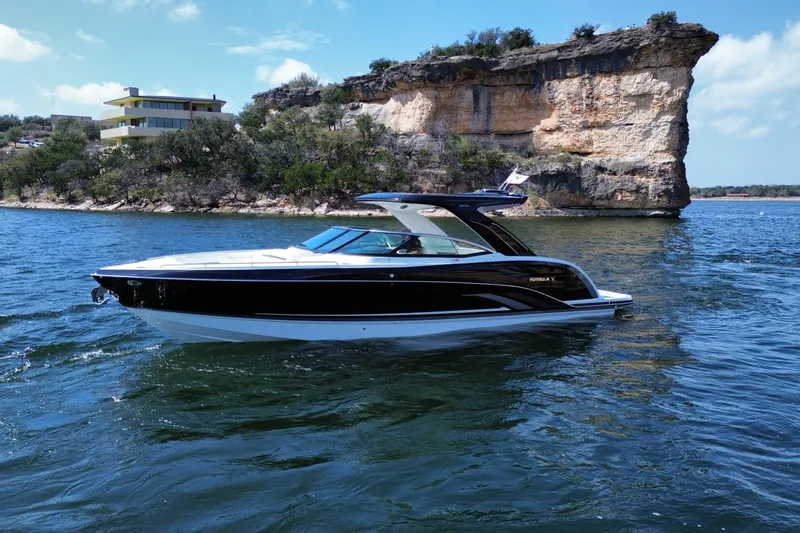 Slide: The Image of 2026 Formula 360 Crossover Bowrider I/O cruising on a scenic lake with rocky cliffs. - 7