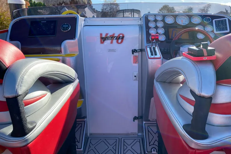 Slide: The Image of Interior of a 2005 Hustler 388 SLINGSHOT boat with red and gray seating. - 12