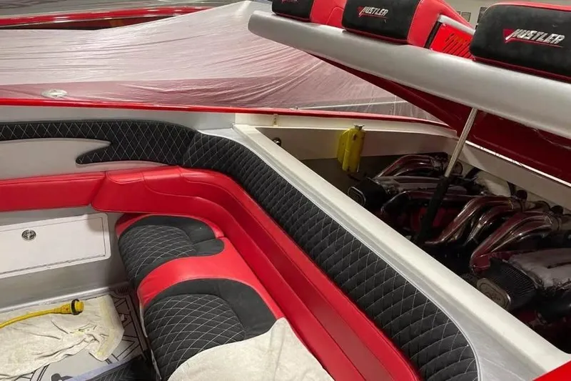Slide: The Image of Interior of a 2005 Hustler 388 SLINGSHOT boat with red and black seating. - 13