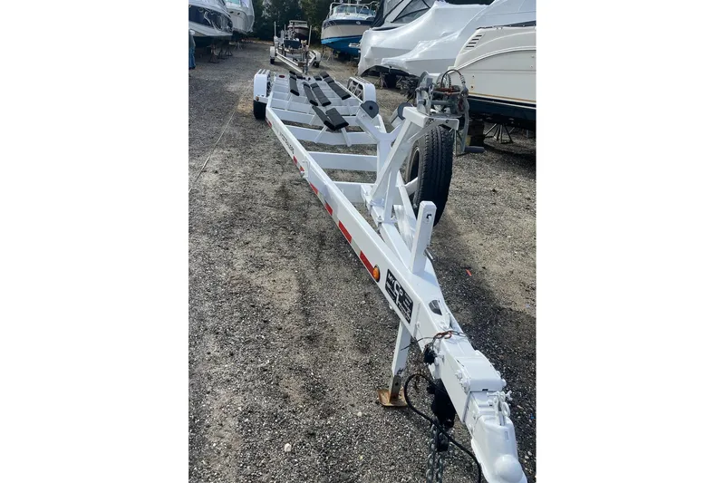 Slide: The Image of 2005 Hustler 388 SLINGSHOT boat trailer in a marina, surrounded by boats. - 20