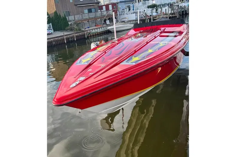 Slide: The Image of Red 2005 Hustler 388 SLINGSHOT speedboat with flame graphics docked by waterfront homes. - 8
