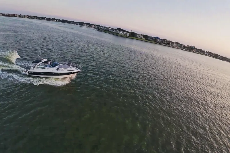 Slide: The Image of 2008 Cranchi Mediterranee 43 yacht cruising on a serene waterway at sunset. - 10