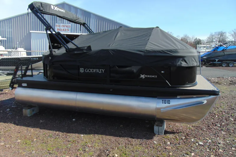 Slide: The Image of 2026 Godfrey EX 1680 CX pontoon boat covered, parked outdoors. - 16
