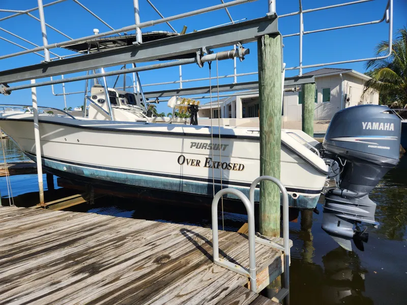 The Image of 2004 Pursuit 2470 Center Console boat on lift with Yamaha outboard motor. - 1