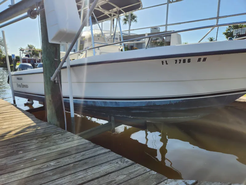 Slide: The Image of 2004 Pursuit 2470 Center Console boat docked at marina, side view. - 17