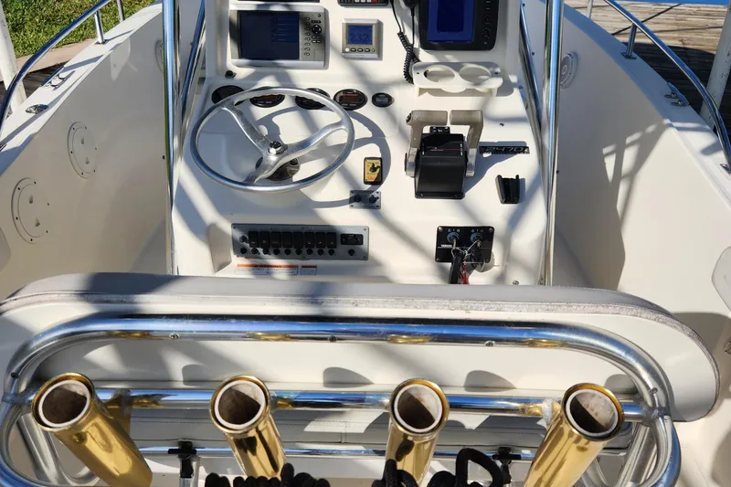 Slide: The Image of 2004 Pursuit 2470 Center Console boat dashboard with steering wheel and controls. - 21