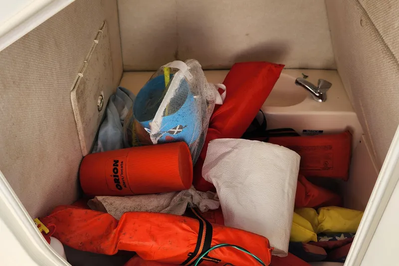 Slide: The Image of Storage compartment with safety gear in a 2004 Pursuit 2470 Center Console boat. - 22
