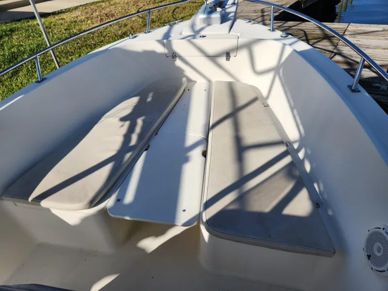 Slide: The Image of 2004 Pursuit 2470 Center Console boat interior with cushioned seating and railings. - 7