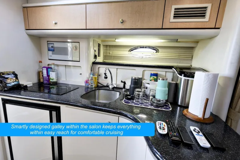 Slide: The Image of Compact galley in 2000 Maxum 3700 SCR yacht with modern amenities and efficient layout. - 13