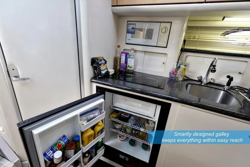 Slide: The Image of Compact galley kitchen in 2000 Maxum 3700 SCR boat with open fridge and sink. - 14