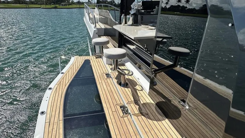 Slide: The Image of Luxury deck of 2024 Galeon 560 Fly yacht with bar stools and scenic water view. - 6
