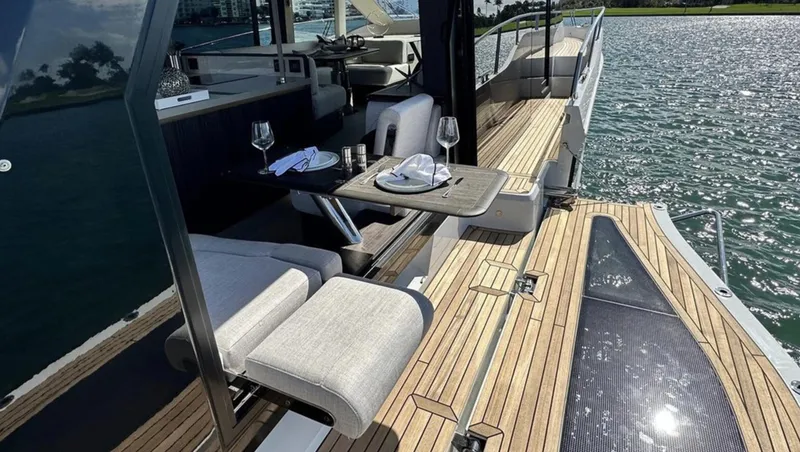 Slide: The Image of 2024 Galeon 560 Fly yacht with elegant outdoor dining setup on teak deck. - 7