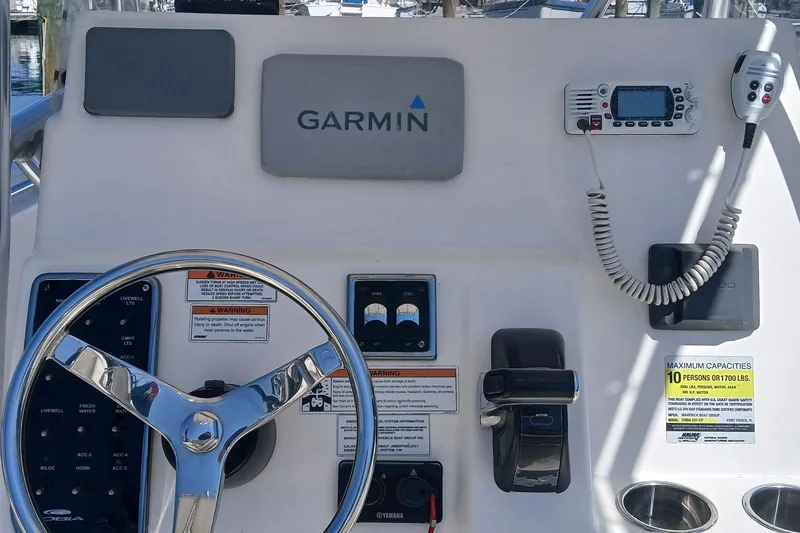 Slide: The Image of 2021 Cobia 237 Center Console helm with Garmin electronics and steering wheel. - 10