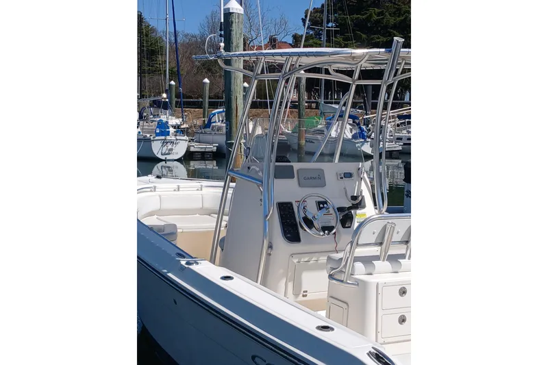 Slide: The Image of 2021 Cobia 237 Center Console boat docked at a marina. - 3