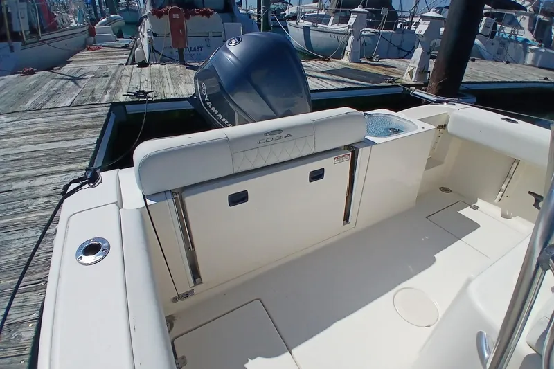 Slide: The Image of 2021 Cobia 237 Center Console boat docked, featuring spacious seating and Yamaha engine. - 4