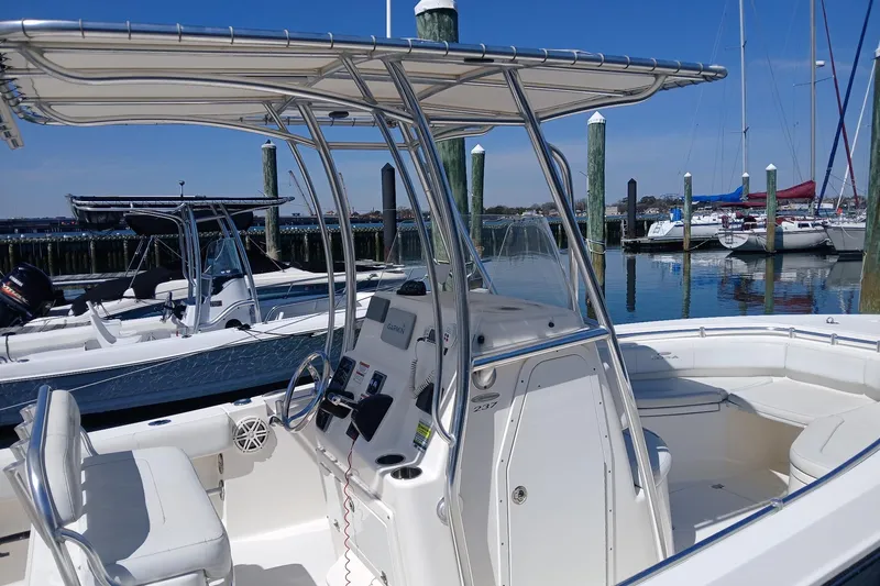 Slide: The Image of 2021 Cobia 237 Center Console boat docked at marina with clear blue sky. - 5