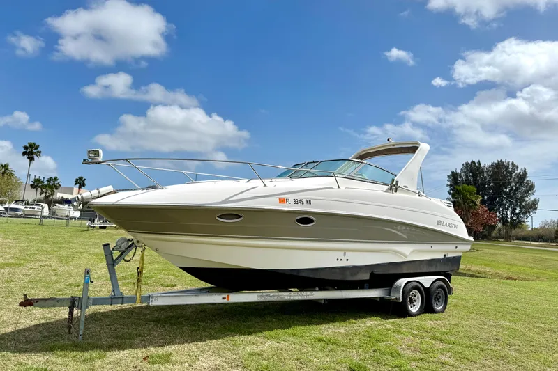 The Image of 2007 Larson Cabrio 274 boat on trailer under blue sky. - 0