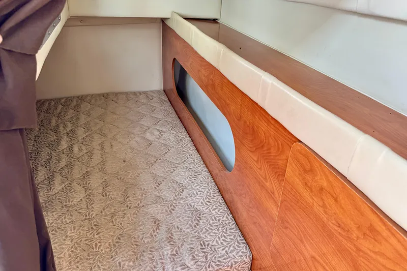 Slide: The Image of 2007 Larson Cabrio 274 interior cabin with wood paneling and patterned carpet. - 17